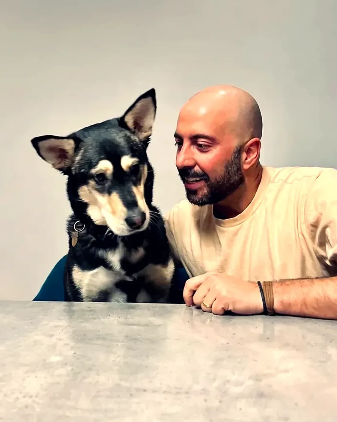 Bruno and his dog Diego side by side at a table, Bruno smiling at him